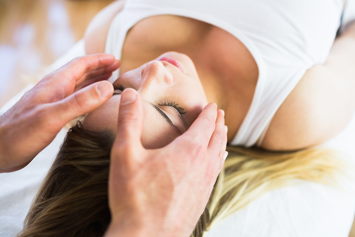 Relaxed pregnant woman enjoying reiki technique in a studio